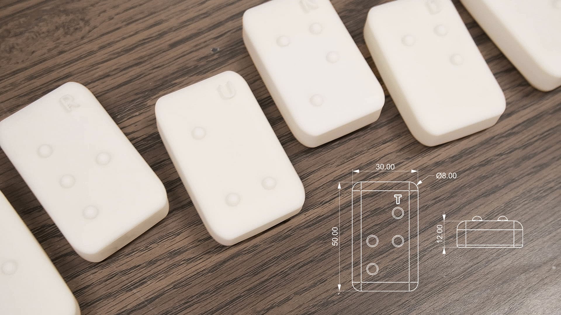 3D-printed letter blocks beside the dimension drawing: 30 by 50 by 12 millimeters with 8 millimeter dots