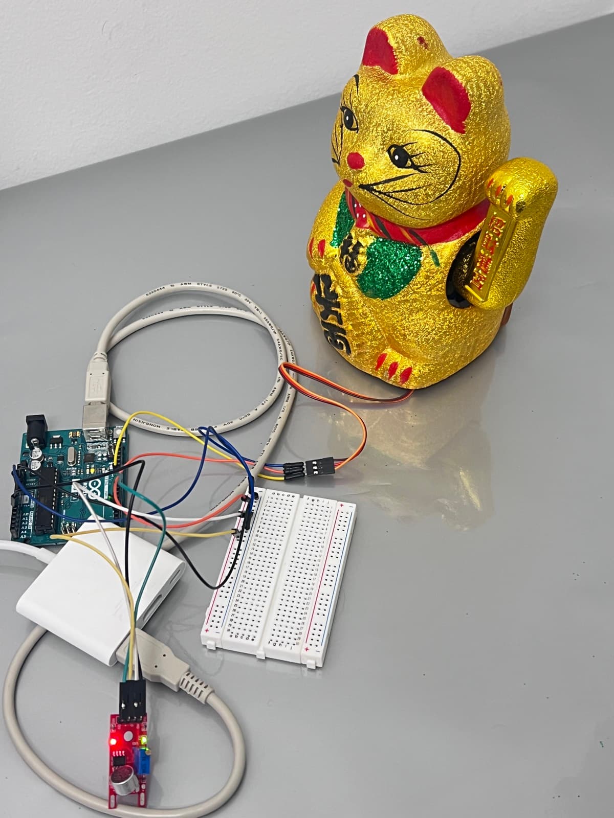 The working bench: Arduino Uno, breadboard, sound sensor, and the cat still wired to it.